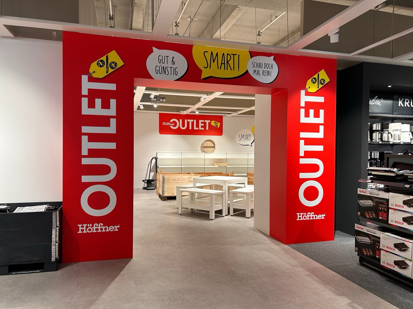 Roter Eingangsbereich des Höffner Outlets mit großem Schriftzug